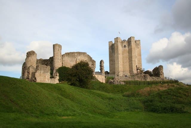The ruined keep and curtain wall of Conisbrough Castle on a grass mound near Doncaster