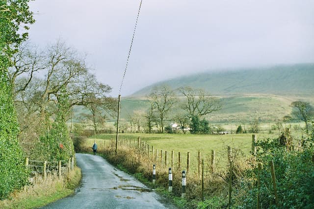 Pendle Hill rising above the lane between Worston and Downham, its summit wreathed in low cloud
