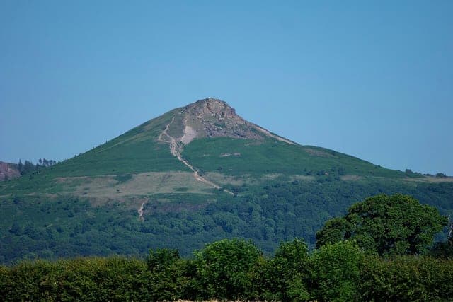 Roseberry Topping's craggy summit rising above woodland on the edge of the Cleveland Hills near Guisborough